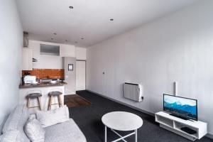 布莱克本Lovely 1 Bed Apartment in Central Blackburn的带沙发和桌子的客厅以及厨房。