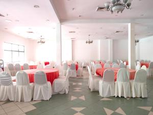 波德申BAYU BEACH RESORT的一间设有红色和白色桌椅的房间