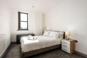 巴恩斯利Modern 1 Bedroom Budget Apartment in Barnsley的一间卧室设有一张床和一个窗口