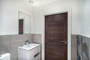 曼彻斯特Modern & Spacious 1 Bed Apartment - Old Trafford的一间带水槽和木门的浴室