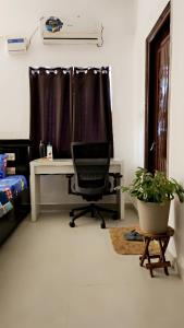 海得拉巴Ruchika's Orchid的窗户客房内的一张桌子和一把椅子
