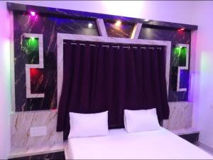 RaxaulHotel Raxaul King的一间卧室配有一张带黑色窗帘的床
