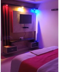 RaxaulHotel Raxaul King的卧室配有一张床,墙上配有电视。