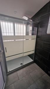 利沃诺Costa rooms apartament的带玻璃门的浴室内的步入式淋浴间