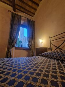 圣吉米纳诺奎切奇奥拉罗坎达旅馆的一间卧室设有一张大床和一个窗户。