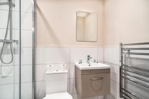 曼彻斯特Modern & Bright 2 Bed Apartment in Manchester的一间带水槽、卫生间和镜子的浴室