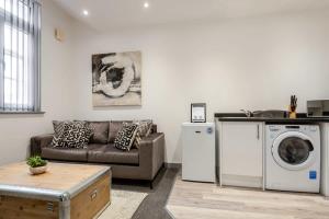唐克斯特1 Bedroom Budget Apartment in Central Doncaster的带沙发、洗衣机和烘干机的客厅