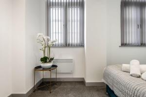 唐克斯特1 Bedroom Budget Apartment in Central Doncaster的一间卧室配有一张床和一张桌子,上面有植物