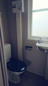 贝尔多夫O'Hara Living的一间带蓝色卫生间的浴室和窗户。