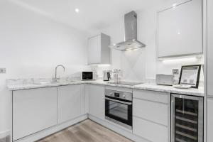 纽伯里Modern 1 Bedroom Apartment in Central Newbury的白色的厨房配有白色橱柜和水槽