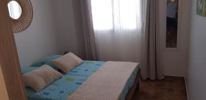 圣保罗Locations Alpinia Réunion的卧室配有带枕头的床铺和窗户。