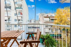 雅典Athens Perfect Spot - Zografou Cozy Home的阳台配有木桌和两把椅子