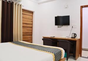 大诺伊达Blue Castle Inn的一间卧室配有书桌、一张床和电视。
