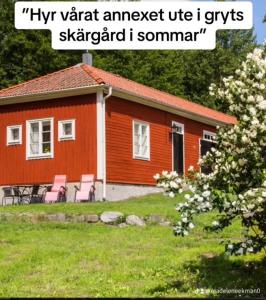 GrytGryts Skägårdscafe & Restaurang的前面有椅子的红色小房子