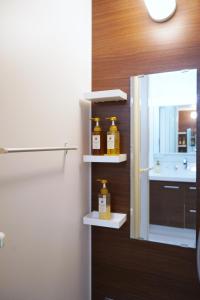 大阪The Peak Chiyozaki的浴室架上放着两瓶蜂蜜