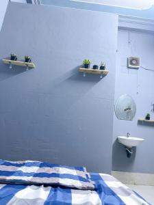 芹苴Nhà Nghỉ Thành Đạt的一间卧室设有蓝色的墙壁、一张床和一个水槽