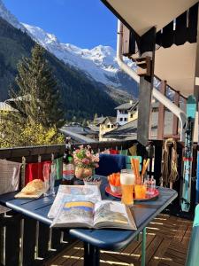 夏蒙尼-勃朗峰Le Petit Cham的阳台上的桌子,上面放着书籍和饮料