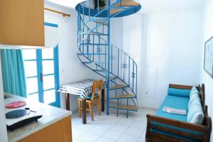 佩里萨Santorini Seaside Retreat - Flora's Summer Escape的蓝色螺旋楼梯,位于带桌子和椅子的厨房