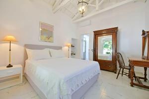 伊兹拉A Sea-licious Vacation - Chic & Style in Hydra的白色卧室配有一张大床和一张书桌