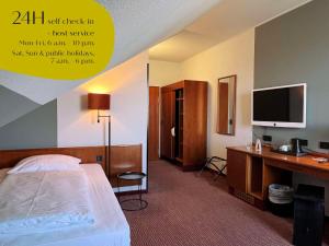 马格德堡马格德堡古典酒店的酒店客房配有一张床和一张书桌及一台电视