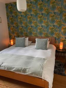 那慕尔La Majolique的一间卧室配有一张蓝色和绿色壁纸的床