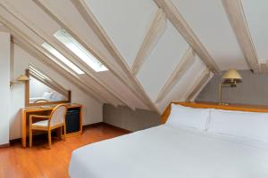 安道尔城伊萨德酒店的一间卧室配有一张床、一张书桌和一面镜子