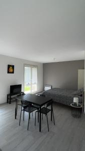 梅斯Studio Pivoine avec terrasse a proximité de Metz的客房设有床、桌子、床和沙发。