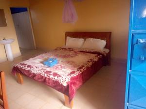 IsuvyaPrudent Guest House的一间卧室配有一张红色棉被的床