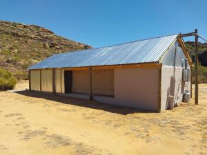 克兰威廉Kleinfontein的沙漠中一座白色的建筑,有金属屋顶