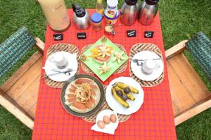 NyakinamaRoom in BB - Red Rocks Rwanda - Safari Tent Twin的一张野餐桌,上面有食物放在红色毯子上