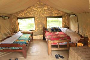 NyakinamaRoom in BB - Red Rocks Rwanda - Safari Tent Twin的一间卧室配有一张床,帐篷内装有窗户