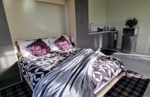 汉密尔顿Sunshine Studio的一间卧室配有一张带紫色枕头的大床
