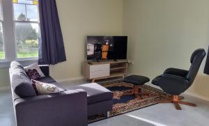 汉密尔顿Sunshine Studio的客厅配有沙发、椅子和电视