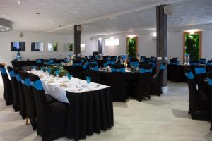 纽基Magnuson Hotel Sandy Lodge Newquay的宴会厅配有带蓝色椅子的桌子和桌子。