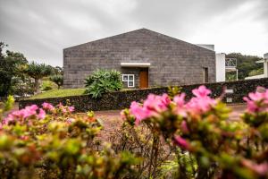 卡罗拉ANC Resort的前面有粉红色花的房子