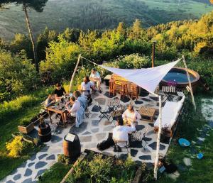 拉莫利纳Minds & Mountains Eco Lodge的坐在庭院桌子上的一群人