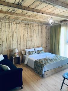 TsʼageriKorenishuli Veranda Wine Hotel的卧室配有一张床铺,位于带木墙的房间内