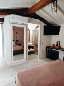 夸尔图-圣埃莱娜Antico Centro Quartu B&B的一间卧室配有一张床和镜子