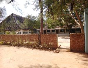 拉穆Subira Guest House and Restaurant的建筑物前的栅栏和树木