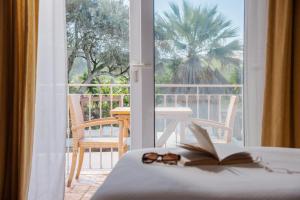 拉戈斯Quinta Bonita Country House & Gardens的一间设有书和眼镜的床的房间
