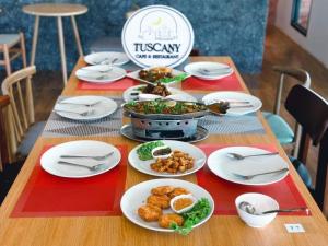 武里南Tuscany Hotel Buriram的上面有盘子的桌子