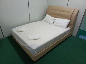 Kampong Tebing RabakHASD GUESTHOUSE的一张小床,配有白色床单和枕头