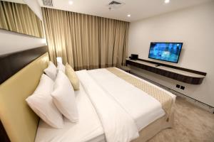 科威特科威特卡尔顿塔酒店的卧室配有一张白色大床和一台平面电视。