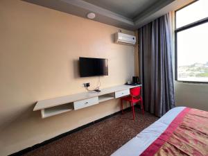 朱巴EASTERN PLAZA HOTEL的酒店客房设有一张桌子、一台电视和一张床