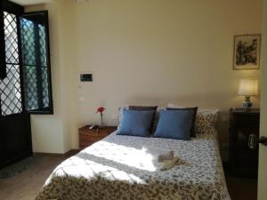卡塔尼亚Tenuta del Gelso的一间卧室配有一张带蓝色枕头的床和一扇窗户。