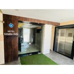 艾哈迈达巴德Hotel Sigma的玻璃门的酒店西吉纳旅馆入口