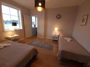 哥德堡Gula Villan的一间卧室设有两张床、两盏灯和一个窗户。