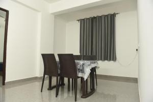 帕纳吉Sai Homestay Panaji 2 BHK and Studio Apartment的餐桌、椅子和窗帘