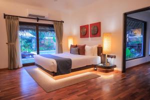 阿勒皮Marari Beach Resort Alleppey- CGH Earth的一间卧室设有一张床和一个大窗户