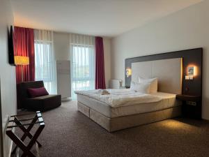 绍尔夫海德Fontane Hotel的酒店客房带一张大床和一把椅子